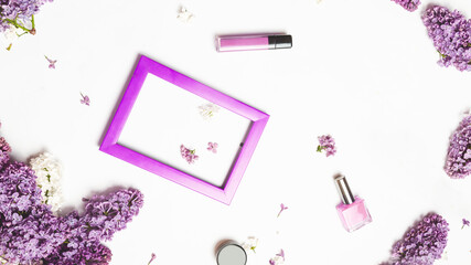 Different makeup cosmetics on white background with space for text with A colored frame decorated with a branch of lilac on a white background.. Flat photo frame and lilac flowers