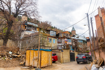 View of old residential buildings at foot of Narikala mountain in Armenian quarter of historic district of Tbilisi overlooking bell towers of Upper and Lower Bethlehem Churches in spring, Georgia