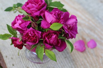 Bouquet of pink roses in a vase on wooden background