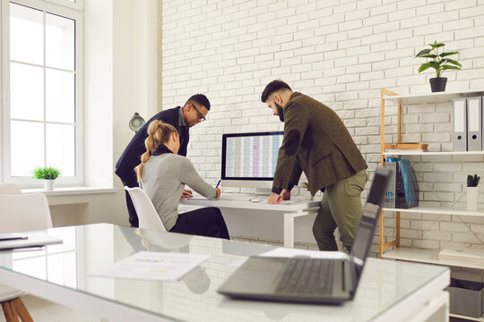 Team of multiethnic business people meeting in office. Group of multiracial colleagues working with digital financial spreadsheets, calculating tax expenses, analyzing revenue, planning future costs