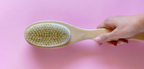 Brush with for dry anti-cellulite massage or brushing in the hand of a girl