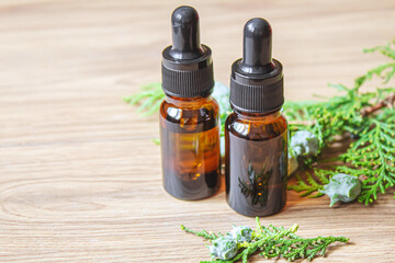 Juniper essential oil in a small bottle. Selective focus.