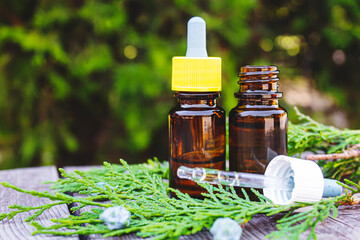 Juniper essential oil in a small bottle. Selective focus.