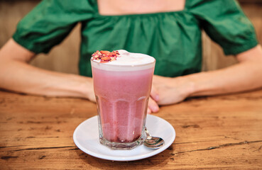 a pink smoothie with unrecognizable woman behind