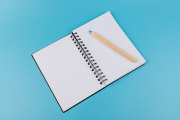 Blank paper and pencil on a blue background