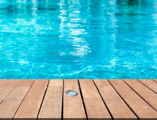 Piscine bleue avec plage bois et spot intégré 