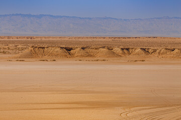 Sandstone rocks in the Sahara desert with the Atlas Mountains on the background in Tunisia