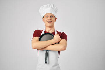 man chef hugging frying pan cooking light background