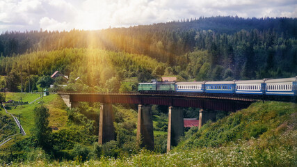 A train crossing a bridge in a mountainous area. The train goes to the Carpathians. Railway bridge...