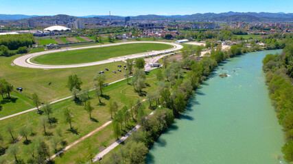 AERIAL: Flying along emerald Sava river and toward a hippodrome near Ljubljana. - obrazy, fototapety, plakaty