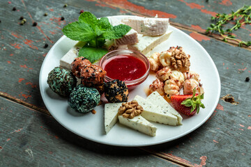 cheese platter with nuts and jam, craft sheep goat cheese, top view