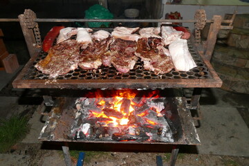 Meaty Brazilian barbecue (churrasco)  with thick sliced beef, pork and sausages over glowing charcoal.  Manaus, Amazonas state, Brazil.