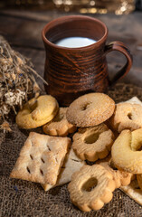 Homemade cookies with a cup of milk on a rural wooden background
