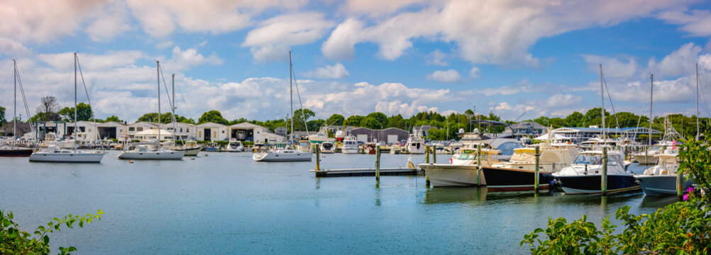Tranquil marina landscape with moored ships under dramatic clouds in Falmouth on Cape Cod.
