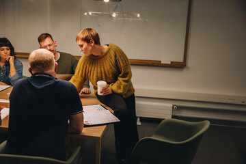 Businesswoman sharing ideas with team in meeting