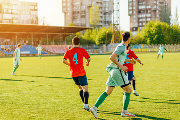 Obraz premium football players in action at the stadium, Football game for adults, Players of two teams competing for the ball