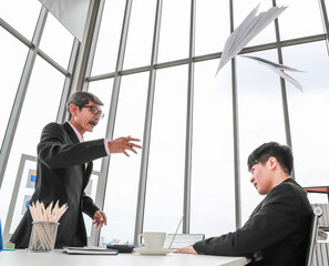 Portrait shot of elderly Asian businessman leader blaming a young employee with serious facial...
