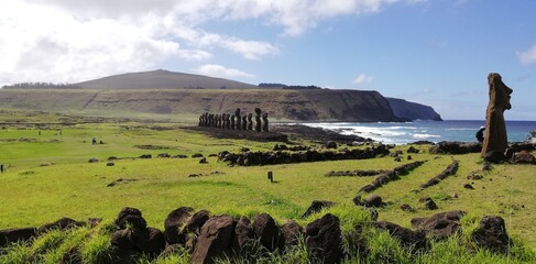 13 moai in Ahu Tongariki, Easter Island. Giant monoliths enclosed between a green lawn and the blue...