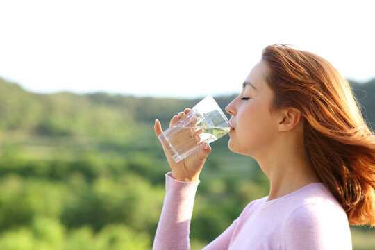 Profile of a woman drinking water from glass outdoor