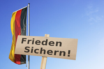 Bundesflagge und Schild mit der Devise 
