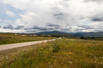 Fototapeta na wymiar Mountain landscape and view in Tsalka, Georgia. Green field and clouds.