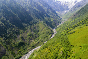 Aerial view of Genaldon river gorge and Mayly glacier on sunny summer day. North Ossetia–Alania, Caucasus, Russia.