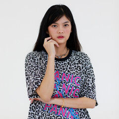 Portrait of an Asian woman with long black hair Wears a black and white striped T-shirt. Standing with arms folded and smiling looking at a camera confidently shoot with white background in a studio