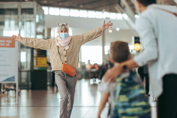 Senior woman welcoming her family at airport after pandemic