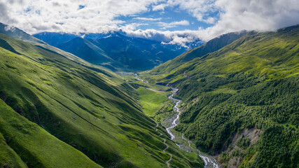 Fototapeta premium Panoramic aerial view of Balkarsky Cherek river gorge and Great Caucasus Range on sunny summer day. Kabardino-Balkaria, Caucasus, Russia.
