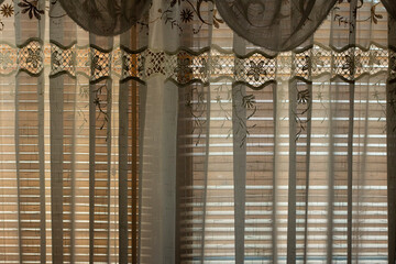 The curtains on the window. Light tulle shades the light from the window.