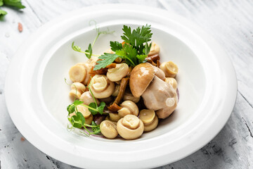 Canned mushrooms in a bowl with pepper and parsley, Food recipe background. Close up