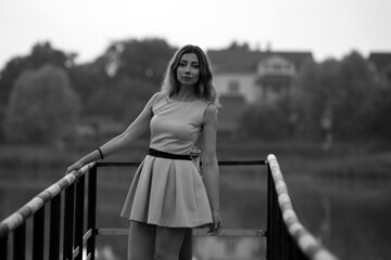 Black and white portrait of beautiful woman standing on the bridge