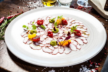 Octopus carpaccio. Spinach cream, cherry tomatoes. Delicious healthy Italian traditional food closeup served for lunch in modern gourmet cuisine restaurant