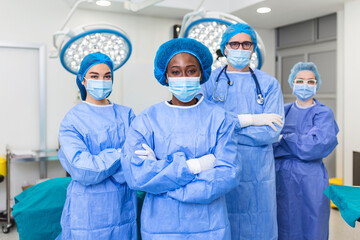Group of medical surgeons wearing hospital scrubs in operating theatre. Portrait of successful...