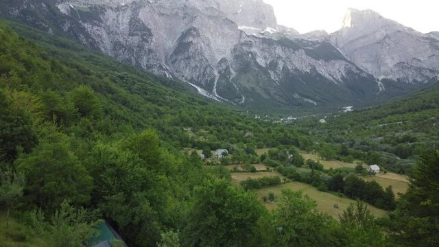 Theth National Park, Albania. Aerial view of albanian alps at sunrise. Flying over green trees overlooking the village of Thethi and majestic mountains. The Accursed Mountains in Albania Prokletije