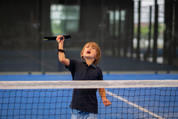 Monitor teaching padel class to child, his student - Trainer teaches little boy how to play padel...