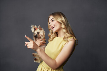 woman in yellow dress with small purebred dog fun fashion posing