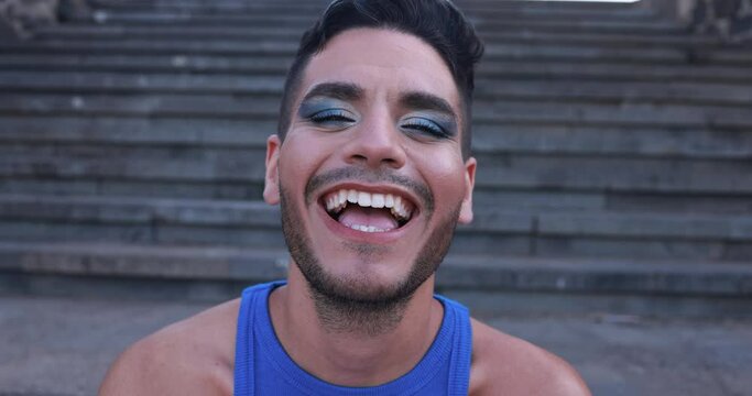 Young transgender man with makeup smiling on camera