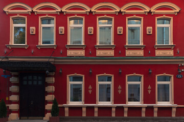 A red building exterior with an entrance by summer day