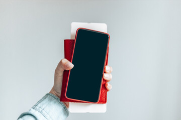 Close up female hand holds template mockup smartphone with black screen isolated on grey background