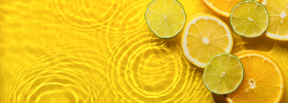 Citrus fruits in yellow water banner with concentric circles and ripples. Refreshing summer concept, Copy space