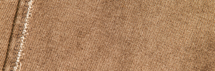 fabric grunge background, real cotton denim, brown, wrinkles, frayed, seam on the canvas, close