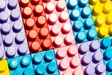 children's play background: the plane of plastic multi-colored bricks, blur, selective focus