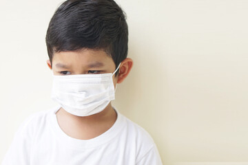 Child wearing protective medical mask to prevent Virus Corona or PM 2.5 concept. Portrait of cute little Asian 2 -3 years old toddler baby boy so sad face.
