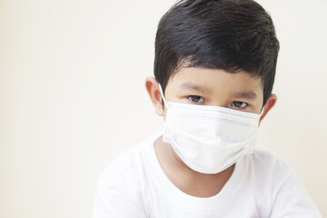 Child wearing protective medical mask to prevent Virus Corona or PM 2.5 concept. Portrait of cute little Asian 2 -3 years old toddler baby boy so sad face.