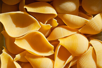 Pasta texture. Many yellow pasta are piled on the pile.