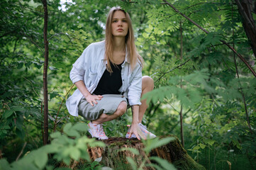 Practice of meditation and interaction with nature. Girl in green forest