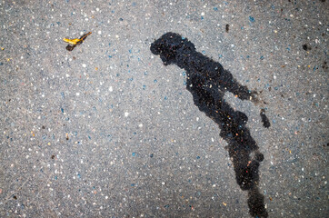 Wet spots on the dark asphalt in the form of a figure of a jumper in the water. He bent down and was about to take the jump. Illustration of visual illusion - pareidolia.