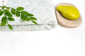 Bathroom towel and organic soap on tray on white table surface