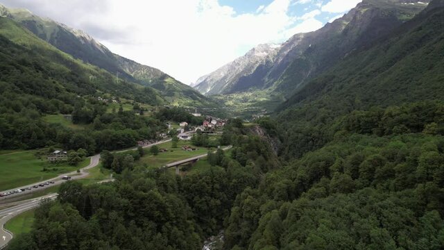 Beautiful alpine panorama with a small village next to the mountain pass road.